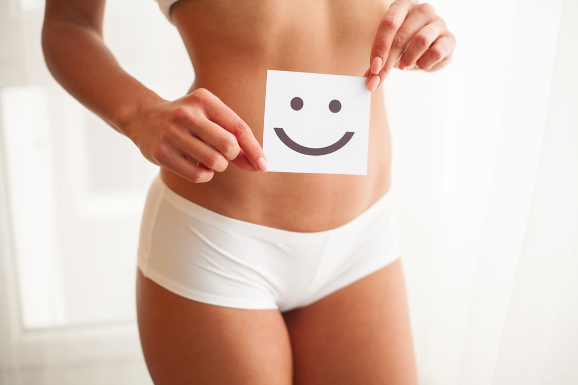 Woman Holding Happy Face Over Stomach 